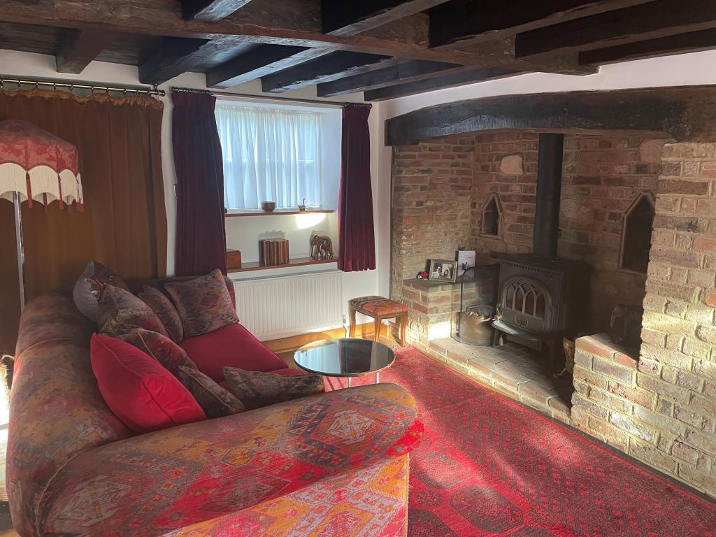 Lot: 101 - CHARACTER COTTAGE IN FAVOURED LOCATION - View of living room / dining room with period fireplace